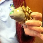 A hedgehog made with a golden pine cone and clay.